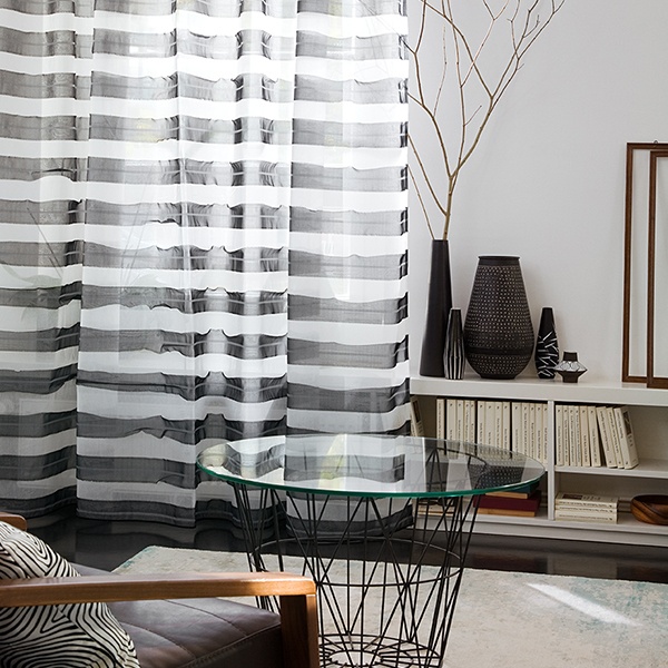 Modernes Wohnzimmer mit Gardinen, Couchtisch mit Glasplatte und minimalistischem Dekor. Firmenadresse