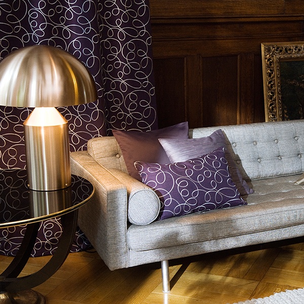 Bild Polsterstoffe Elegante Wohnecke mit modernem Sofa, Dekokissen, Gardinen und einer Tischlampe aus Metall. Firmenadresse